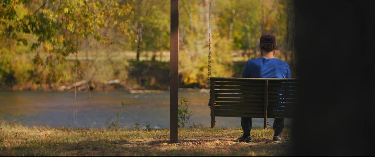 Landon on porch swing by river